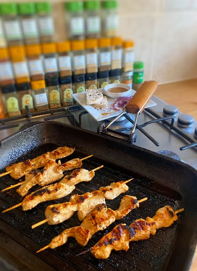 skewers cooking in a griddle pan